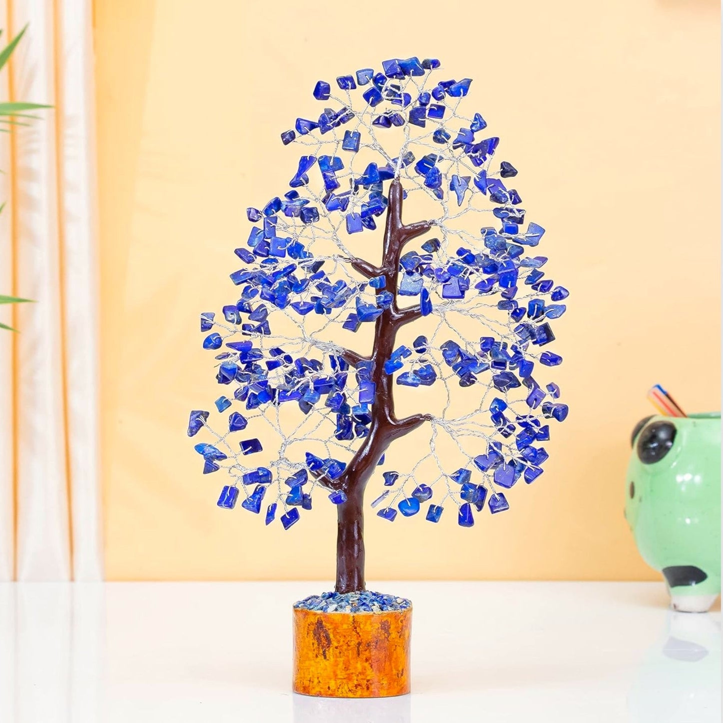 Decorative tree with blue stones against a yellow wall