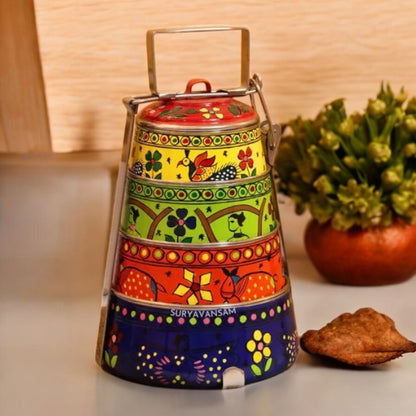 A hand-painted 4 tier steel tiffin box with multicolor designs, displayed on a table.