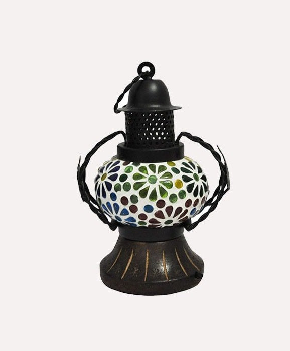 A handcrafted wooden lantern with a multicolored patterned glass panel and a black metal chimney, designed for indoor hanging