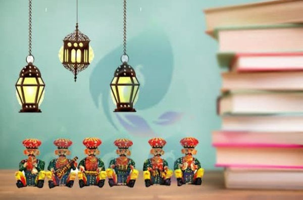 A set of six hand-painted wooden musician figurines, each multicolored and playing different traditional Indian instruments, displayed in front of a backdrop featuring books and hanging lanterns.