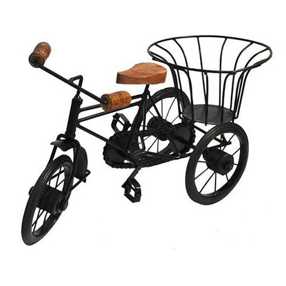 A handcrafted iron and wood cycle rickshaw table top showpiece with a basket and pedals.