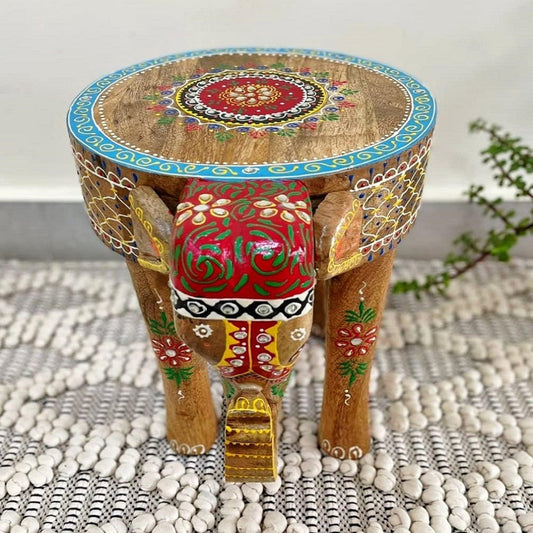 A hand-crafted wooden elephant stool with a hand-painted design, featuring floral patterns and global style accents on a 12-inch tall stool.