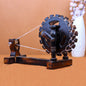 A wooden antique showpiece resembling a Gandhi charkha, with a spinning wheel and a base, displayed against a neutral background.
