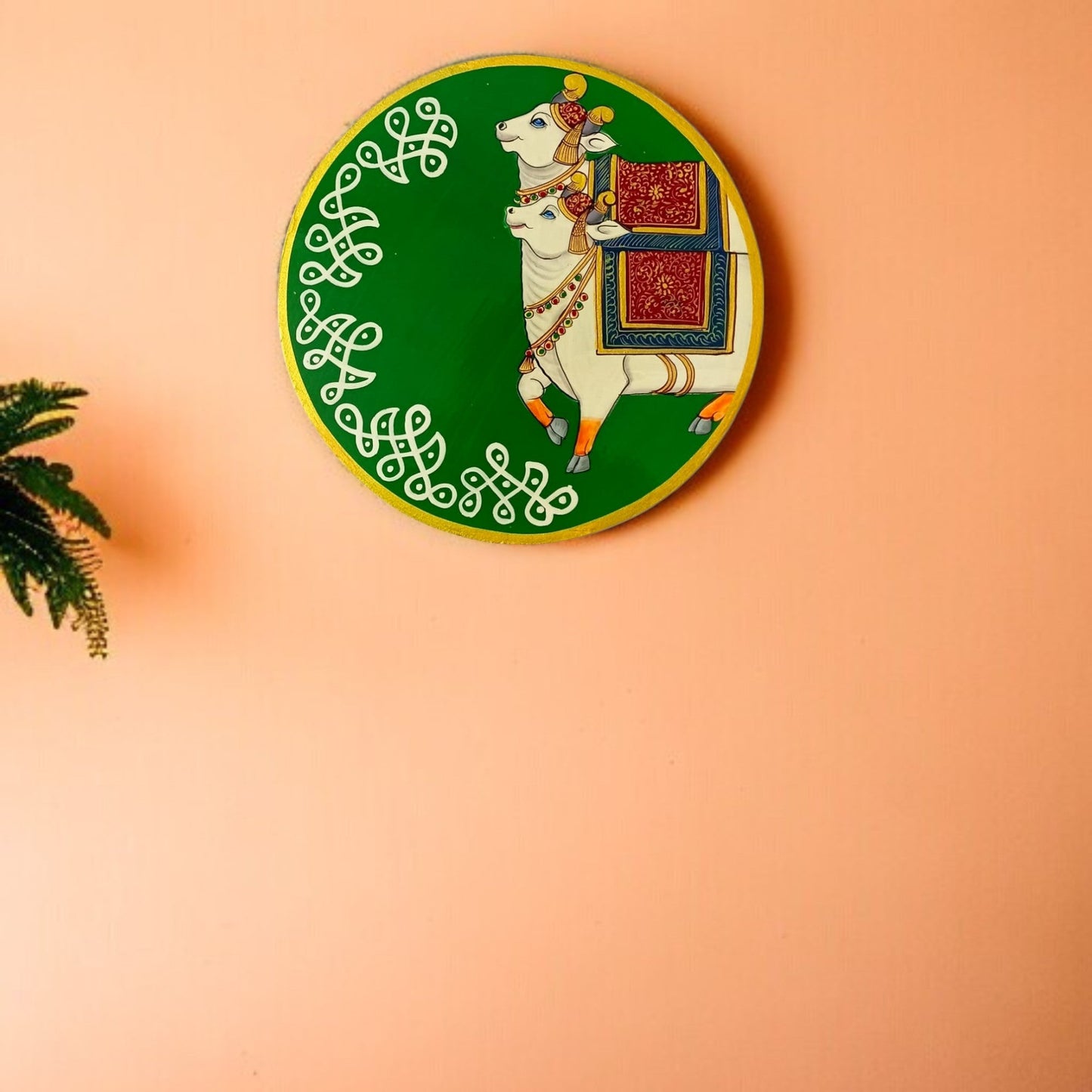 Decorative plate with a white goat and green border on a peach background