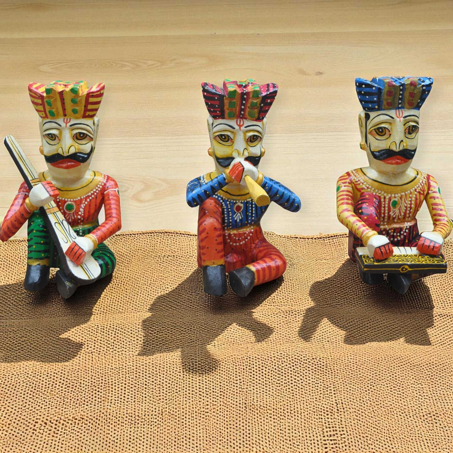 Three colorful figurines with traditional attire on a textured surface