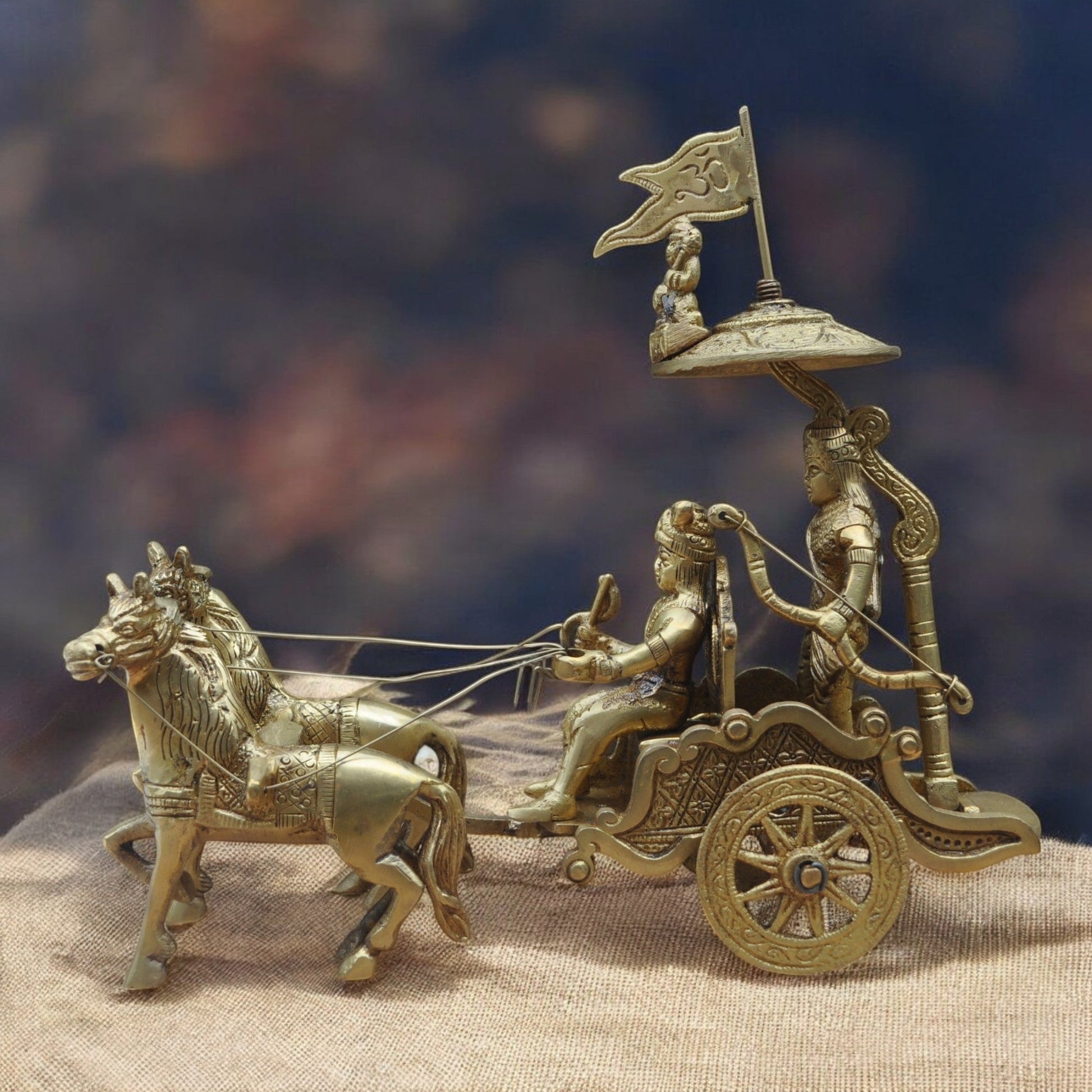 Bronze chariot with horses and figures on a textured surface