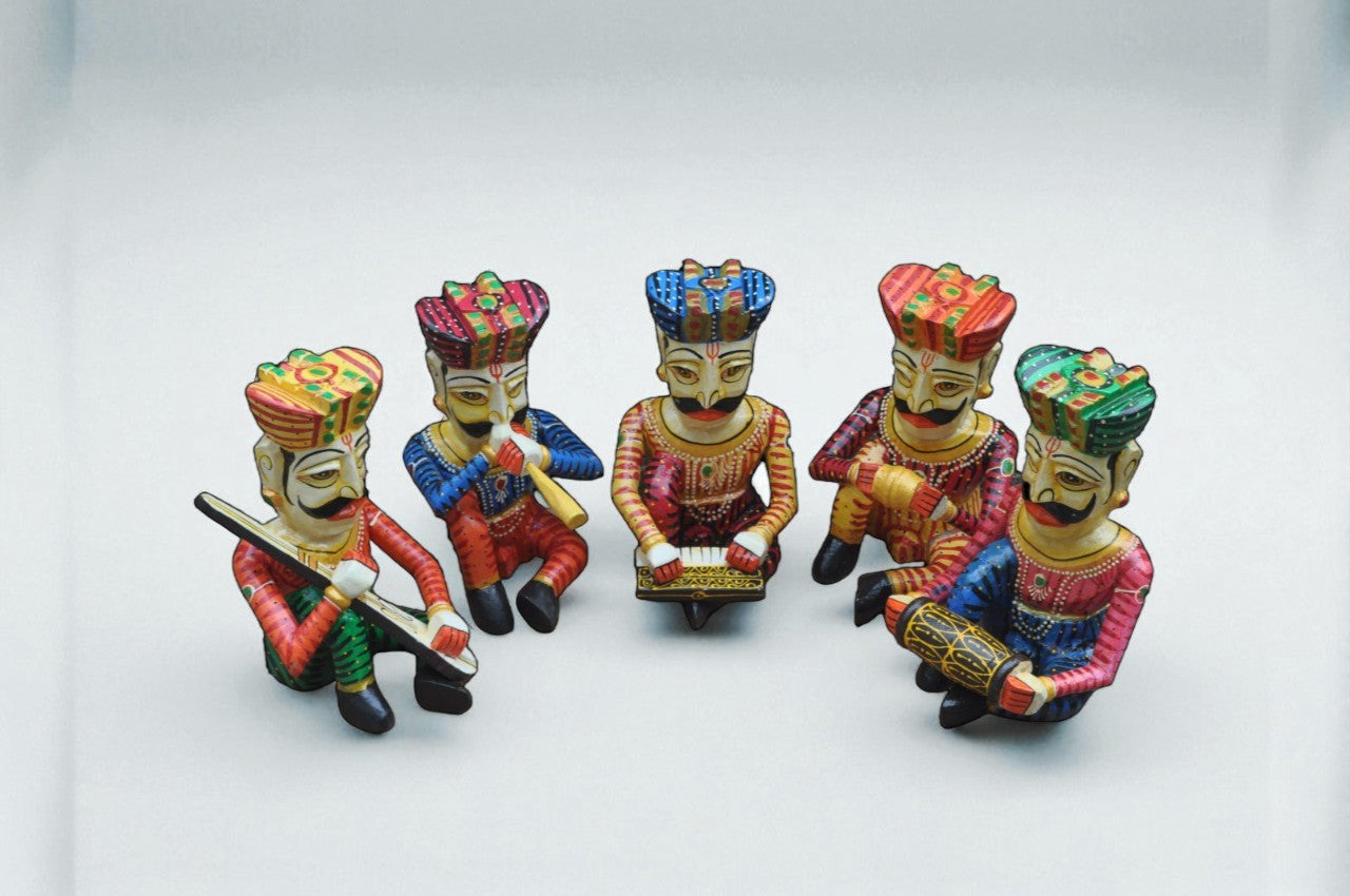Set of five colorful figurines with traditional attire on a white background