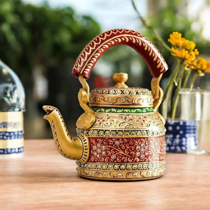 A colorful hand-painted aluminum tea kettle figurine with a wooden handle, displayed on a table.